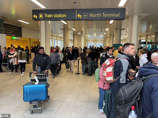 Gatwick Airport Ltd is quick to point out that staff preparing to strike are not employed by the airport. Pictured, travellers queue for taxis at Gatwick Airport in West Sussex