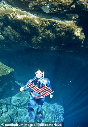 Tiffany poses with a US flag during one of her deep dives